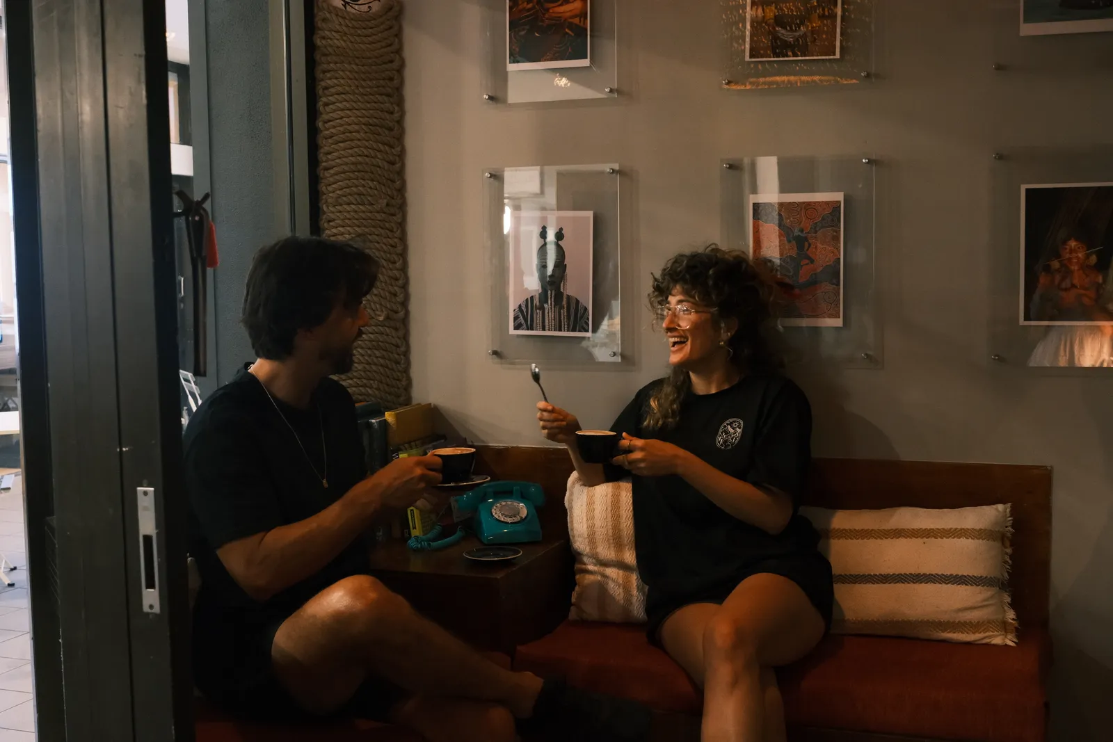 Two people with coffee on the sofa inside the café.
