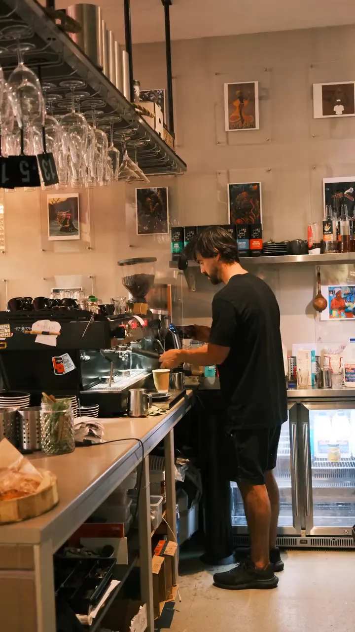 Rafa making coffee behind the counter at Ritual Café